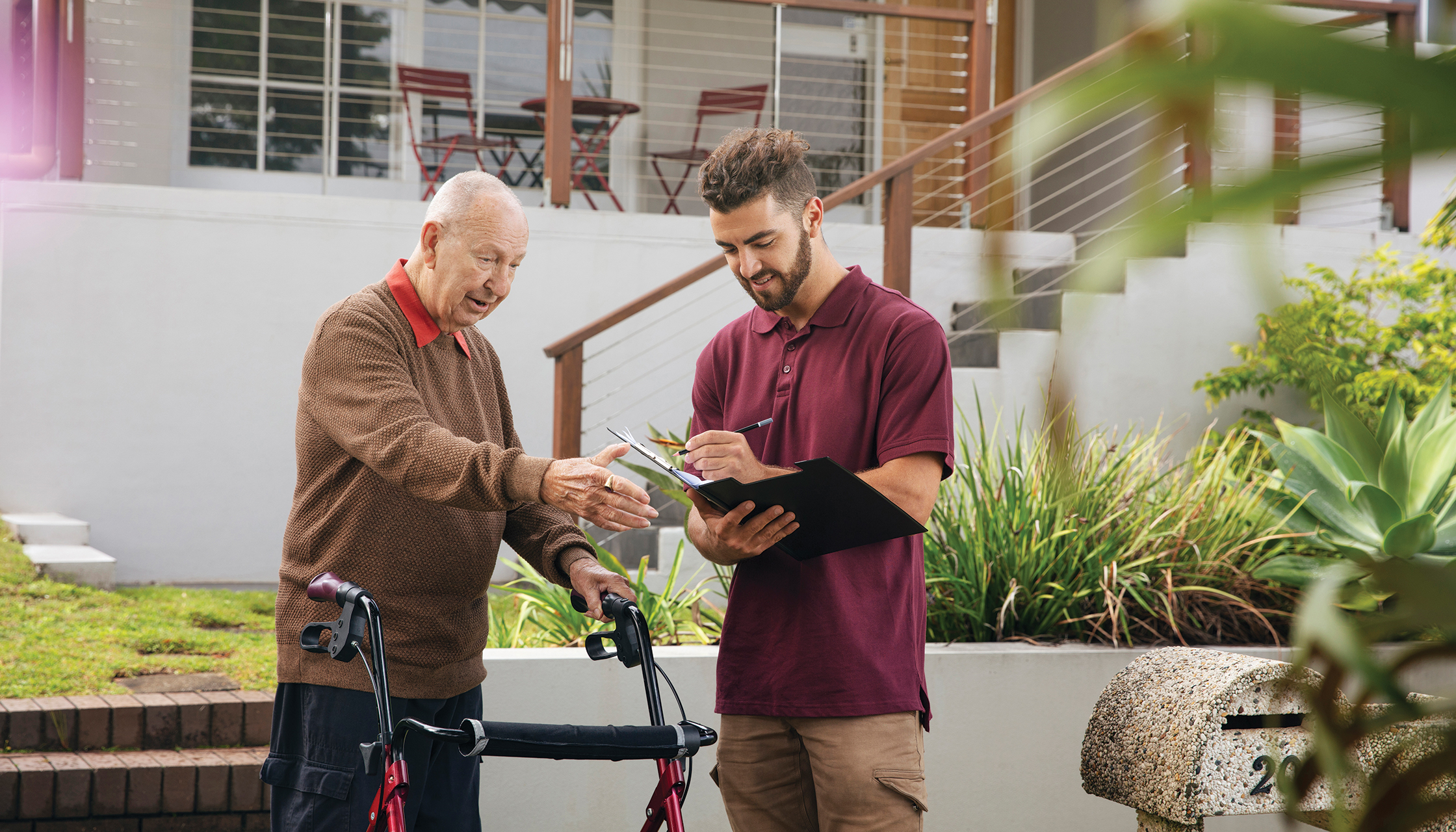 Aged care worker filling documents for older man
