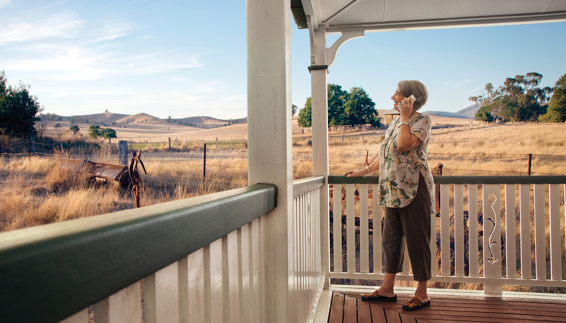 Older woman on verandah talking on phone