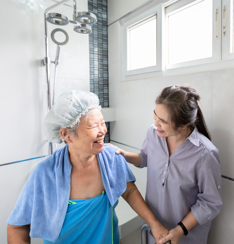 Carer helping elderly lady out of shower