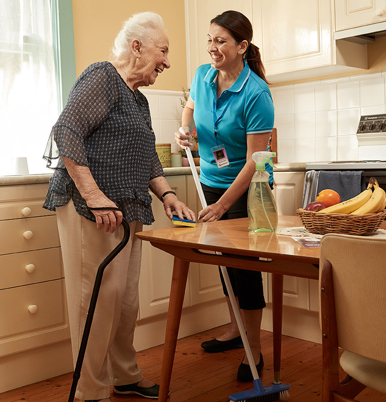 Carer helping elderly lady clean