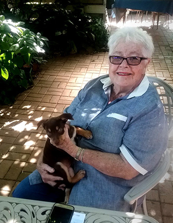 Photo of Carolyn smiling and holding a puppy